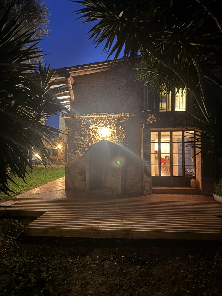Finca bei Nacht — beleuchtete Holzterrasse