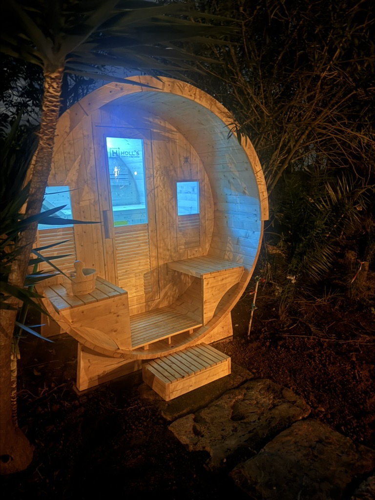 Fasssauna bei Nacht mit blauem Licht